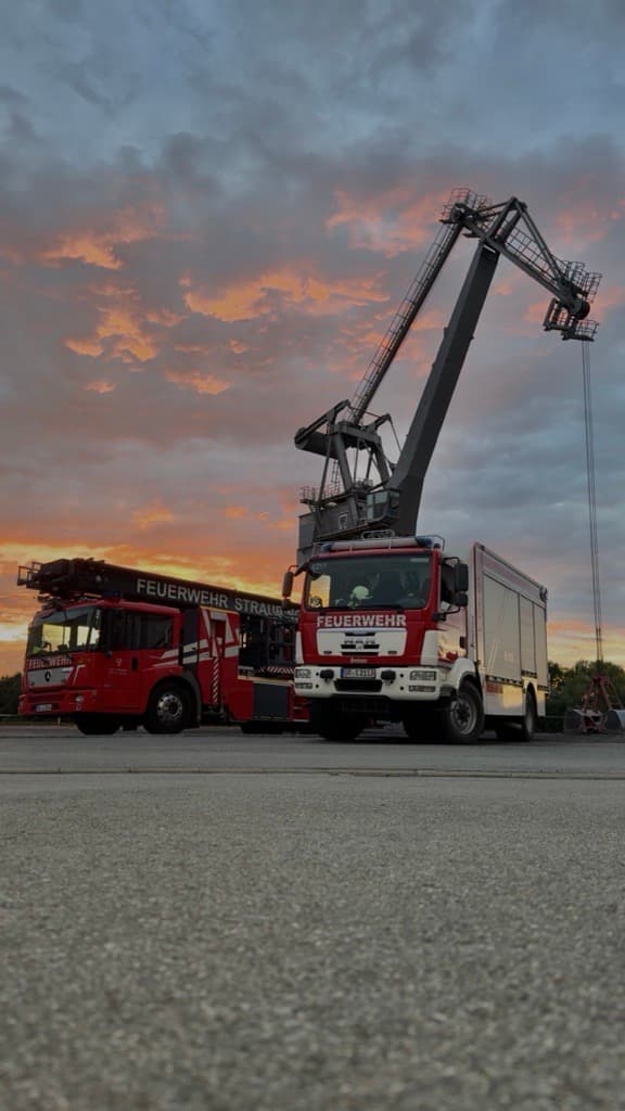 Zwei Feuerwehrfahrzeuge während Sonnenuntergang